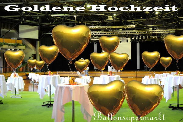 Dekoration Goldene Hochzeit mit großen, goldenen Herzluftballons aus Folie die mit Helium schweben