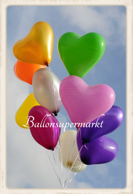 40-45 cm große Herzluftballons, bunte Auswahl, mit Ballongas-Helium, schwebend am Horizont