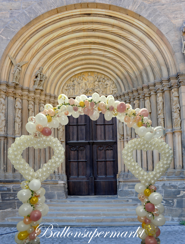 Ballondekoration Hochzeit, Ballonbogen Organische Girlande, Herzen aus Luftballons vor einem Kirchenportal