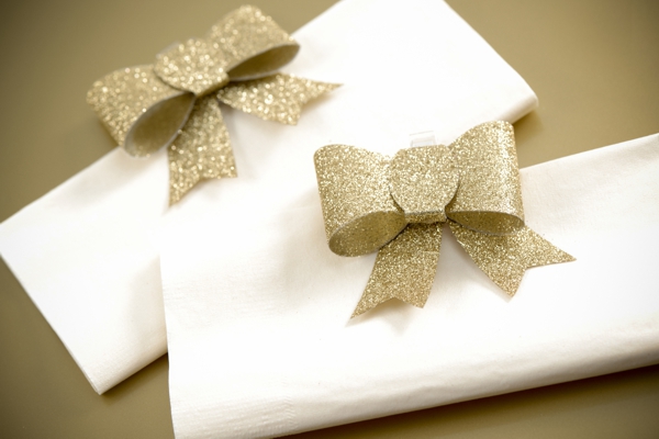 Goldene Glitter-Zierschleifen als Serviettenhalter - Tischdekoration