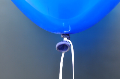 Luftballon der mit weißem Ballonband verschlossen ist